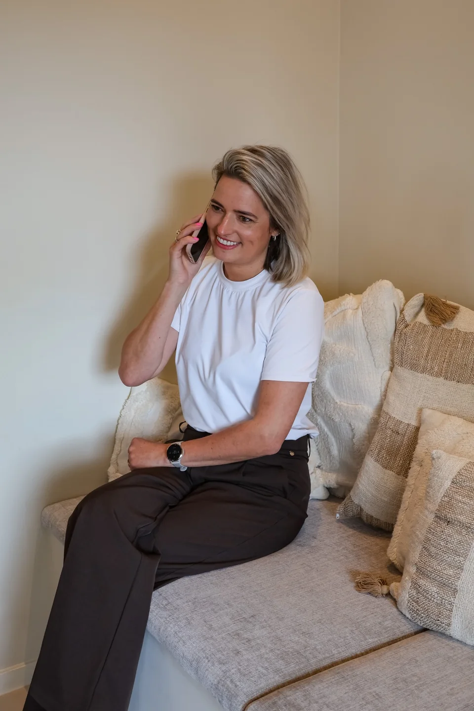 Daniëlle glimlacht tijdens een telefoongesprek op de bank
